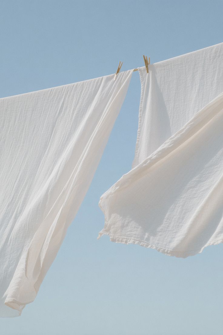 White linens drying on a clothesline against blue sky